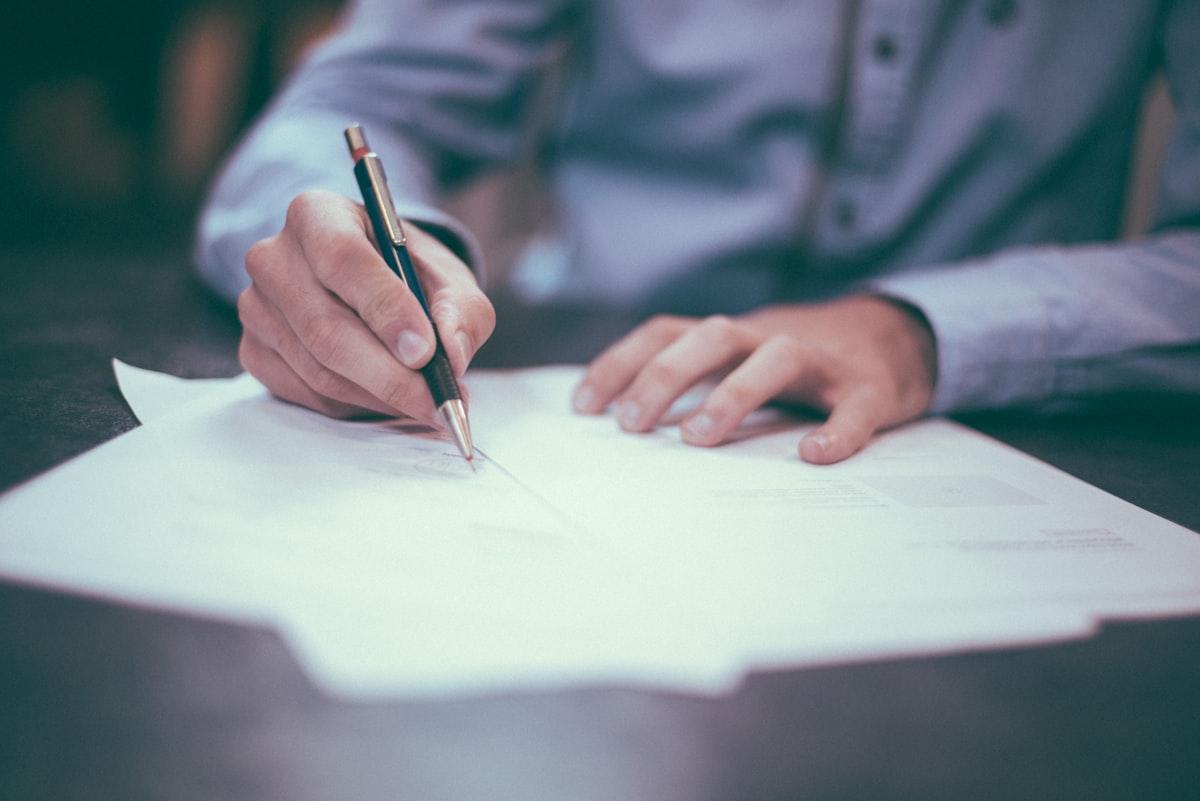 A planner&rsquo;s hand using a mechanical pencil to mark figures on a worksheet during a consultation.
